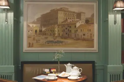 a dining room with a painting of a city at Stendhal Hotel in Rome