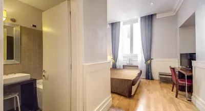a small room with a bed and a sink and a bathroom at 939 Hotel in Rome