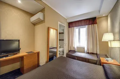 a hotel room with two beds and a television at 939 Hotel in Rome