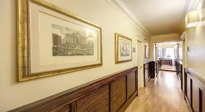 a hallway with paintings on the walls of a house at 939 Hotel in Rome