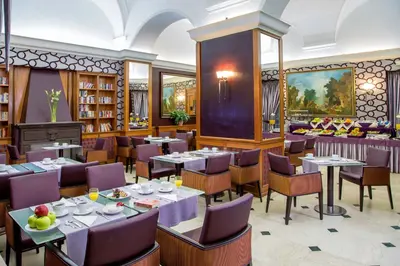 a restaurant with tables and chairs in a library at Hotel Morgana in Rome