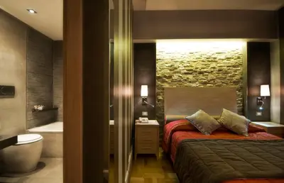 a bedroom with a bed and a bathroom with a tub at Hotel Morgana in Rome