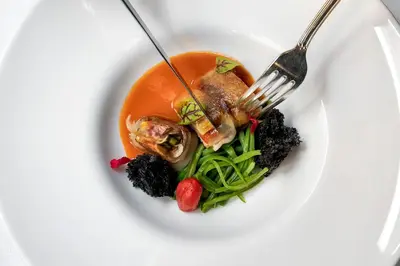 a white plate with a bowl of food with a fork at Baglioni Hotel Regina - The Leading Hotels of the World in Rome