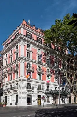 a large pink and white building on a street at Baglioni Hotel Regina - The Leading Hotels of the World in Rome