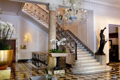 a staircase in a building with a chandelier at Baglioni Hotel Regina - The Leading Hotels of the World in Rome