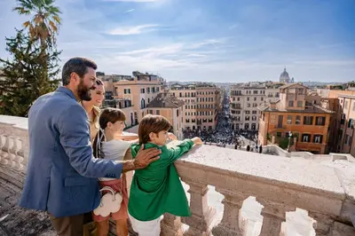 a man holding a little boy looking at a city at Baglioni Hotel Regina - The Leading Hotels of the World in Rome