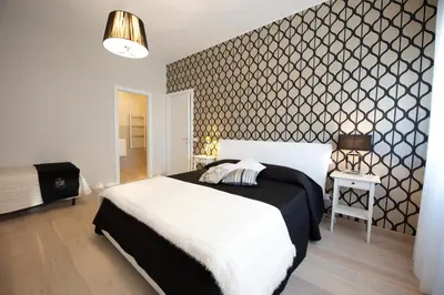 a bedroom with a bed with a black and white patterned wall at Quartopiano Guesthouse in Rome