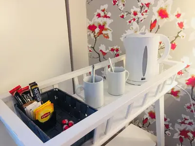 a white shelf with cups on it in a room at Quartopiano Guesthouse in Rome
