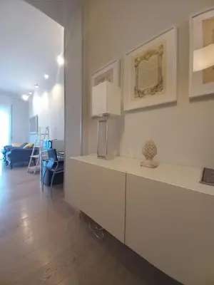 a living room with a white cabinet with a vase on it at Quartopiano Guesthouse in Rome
