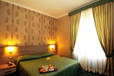 a hotel room with a green bed and a window at Hotel Argentina in Rome