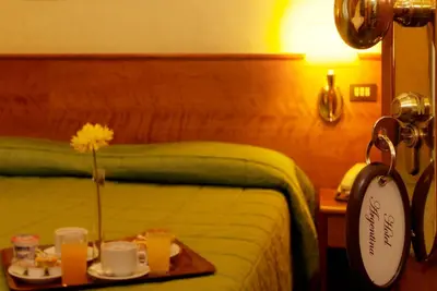 a hotel room with a bed with a tray of food at Hotel Argentina in Rome