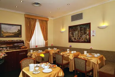 a dining room with tables and chairs with yellow table cloth at Hotel Argentina in Rome
