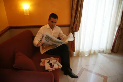 a man sitting on a couch reading a newspaper at Hotel Principessa Isabella in Rome