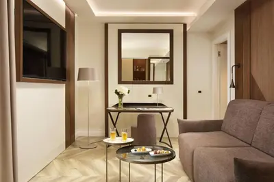 a living room with a couch and a table at FH55 Grand Hotel Palatino in Rome