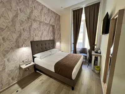a bedroom with a bed and a wall mural at Hotel Le Petit in Rome