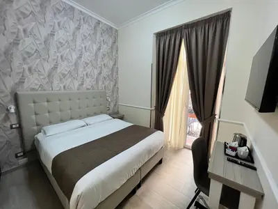 a hotel room with a bed and a window at Hotel Le Petit in Rome