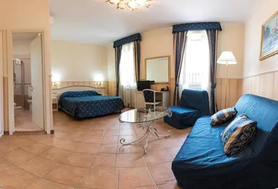a living room with a couch and a bed and a table at Hotel Anfiteatro Flavio in Rome