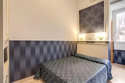 a bedroom with a bed and a painting on the wall at Hotel Anfiteatro Flavio in Rome