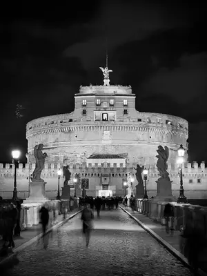 a large building with people walking in front of it at night at Hotel Raganelli in Rome
