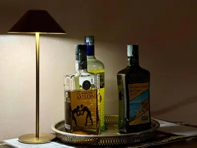two bottles of alcohol on a table next to a lamp at Lilium Boutique Hotel in Rome