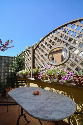 a table and chairs on a balcony with flowers at Lilium Boutique Hotel in Rome