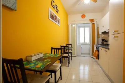 a dining room with yellow walls and a table and chairs at Vatican Station in Rome