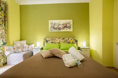 a bedroom with a large bed with green walls at Vatican Station in Rome