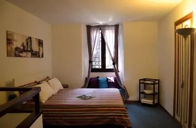 a small bedroom with a bed and a window at Palazzo Velli Suites in Rome