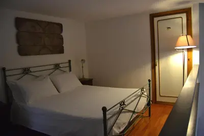 a bedroom with a bed with white sheets and a lamp at Palazzo Velli Suites in Rome