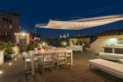 a white table and chairs on a deck at night at Nostromondo Ciancaleoni Palace in Rome