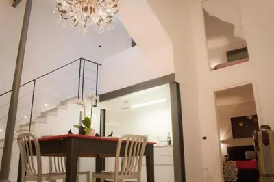 a dining room with a table and chairs and a chandelier at Nostromondo Ciancaleoni Palace in Rome