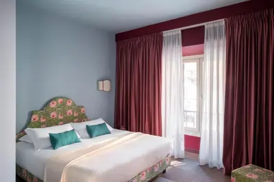 a hotel room with two beds and a chair at Hotel Cortina in Rome