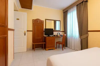 a bedroom with a bed and a desk with a television at Hotel Virgilio in Rome