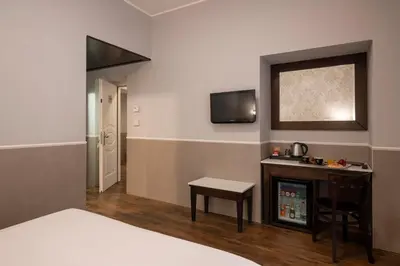 a bedroom with a bed and a table and a television at Hotel Virgilio in Rome