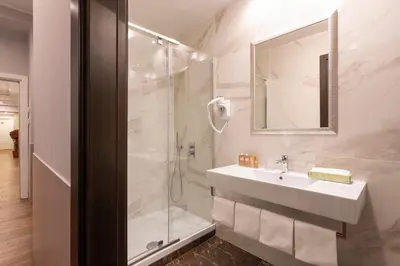 a white bathroom with a sink and a shower at Hotel Virgilio in Rome