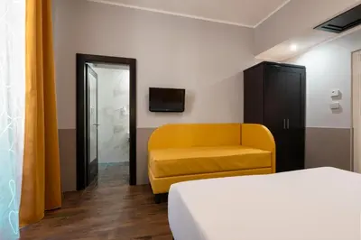 a room with a bed and a yellow couch at Hotel Virgilio in Rome