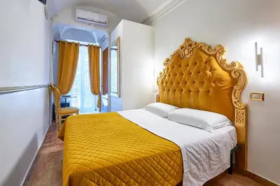 a bedroom with a large yellow bed in a room at Hotel Virginia in Rome