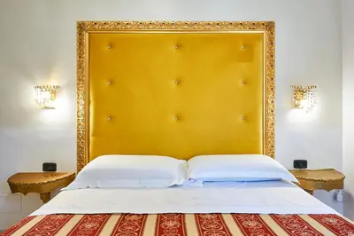 a bed with a large gold headboard in a room at Hotel Virginia in Rome