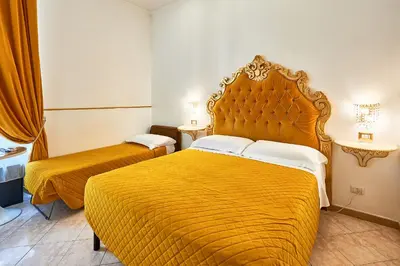 a bedroom with two beds and a large yellow bed at Hotel Virginia in Rome