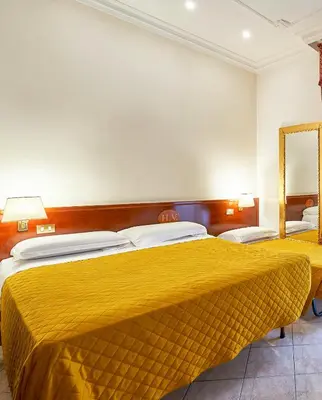 a bedroom with two beds with a yellow bedspread at Hotel Virginia in Rome