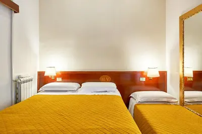 a bedroom with two beds and a mirror at Hotel Virginia in Rome