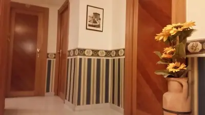 a hallway with a door and a vase with flowers at Hotel Teti in Rome
