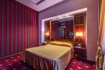 a bedroom with a bed and red drapes at Atlante Garden Hotel in Rome