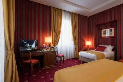 a hotel room with two beds and a television at Atlante Garden Hotel in Rome