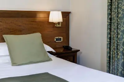 a bedroom with a bed with a pillow and a lamp at Grand Hotel Gianicolo in Rome