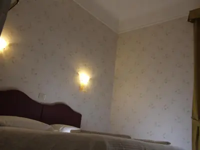 a bedroom with a bed and two lights on the wall at Hotel Texas in Rome