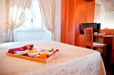 a tray with food and drinks on a bed at Hotel Priscilla in Rome