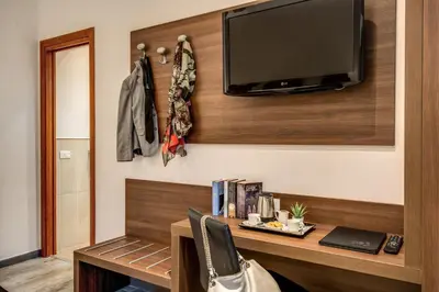 a room with a desk with a television on a wall at Rome Garden Hotel in Rome