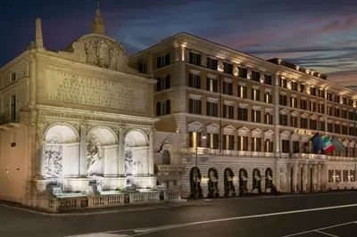 a large building with lights on it at night at The St. Regis Rome in Rome