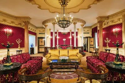 a living room with red furniture and a chandelier at The Westin Excelsior, Rome in Rome